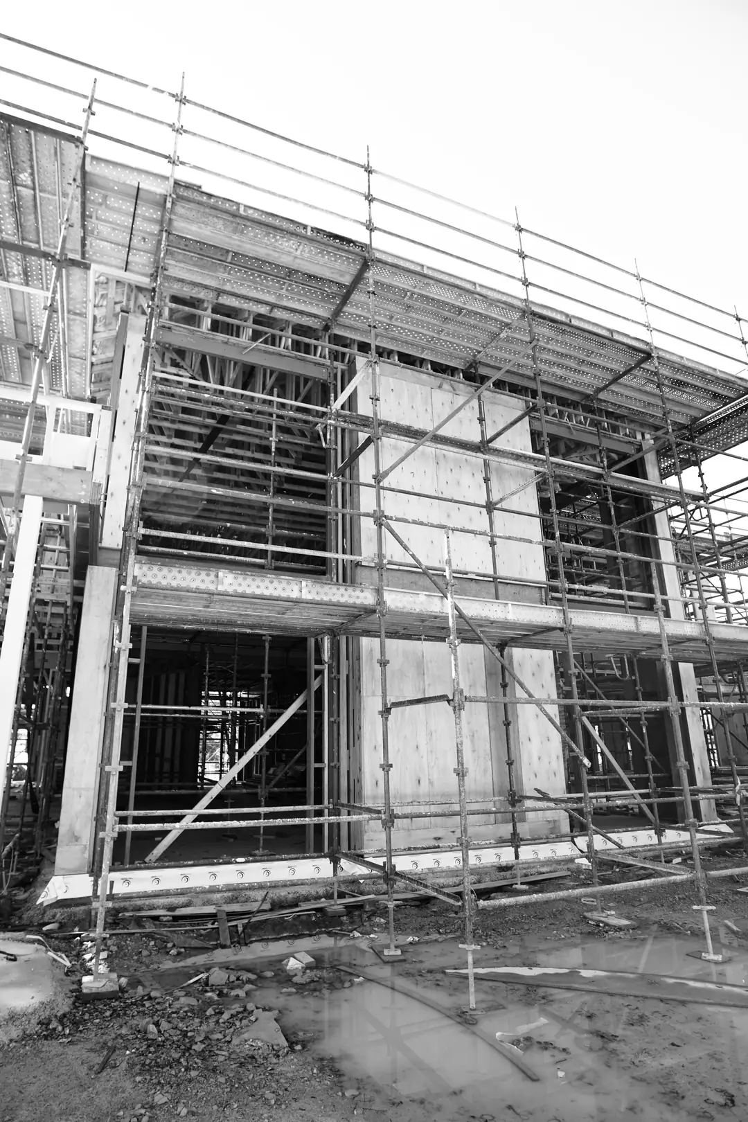 Two-storey timber-framed building wrapped in scaffolding